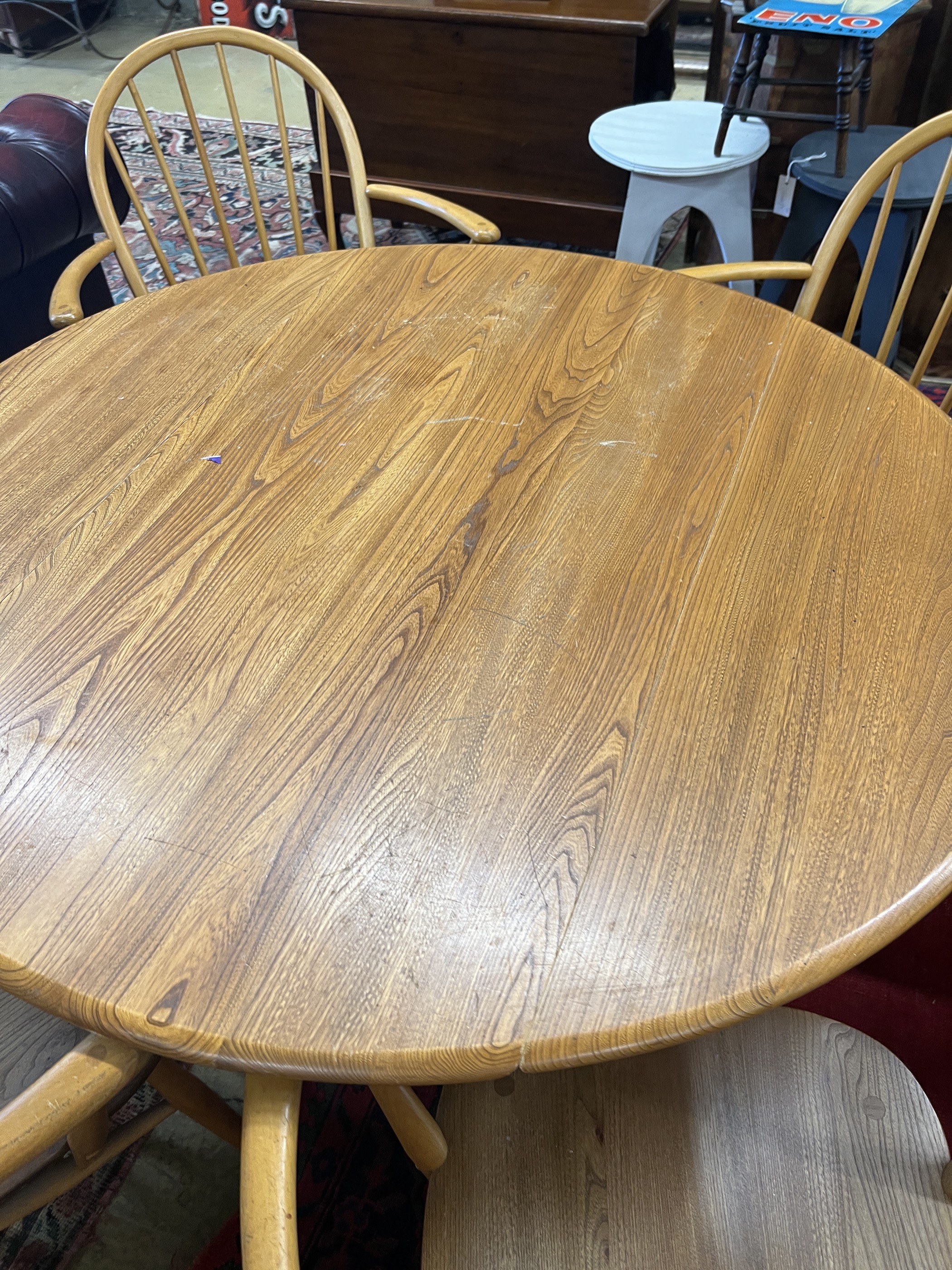 An Ercol oval elm drop leaf dining table, length 123cm extended, width 113cm, height 71cm and four Ercol elm and beech elbow chairs